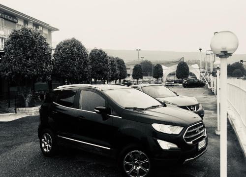a black car parked in a parking lot at 7 LAKES Aparthotel in Burolo