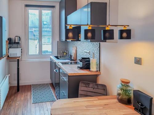 a kitchen with a table and a stove and a window at The blue suite Etretat in Étretat