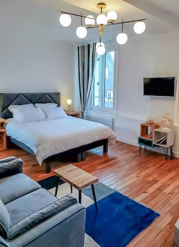 une chambre avec un grand lit et un canapé dans l'établissement The blue suite Etretat, à Étretat