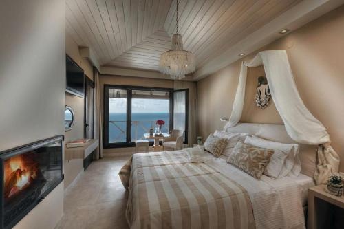 een slaapkamer met een bed, een open haard en een televisie bij Karavia Lux Inn in Afissos