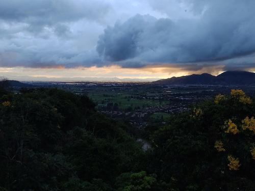 a view of a valley with trees and a cloudy sky at La Casita de Chocolate 3 in Bogotá