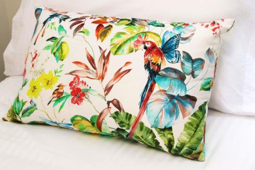 ein Kissen mit einem bunten Vogel darauf auf einem Bett in der Unterkunft Welcoming House in Medros with Terrace in Medros
