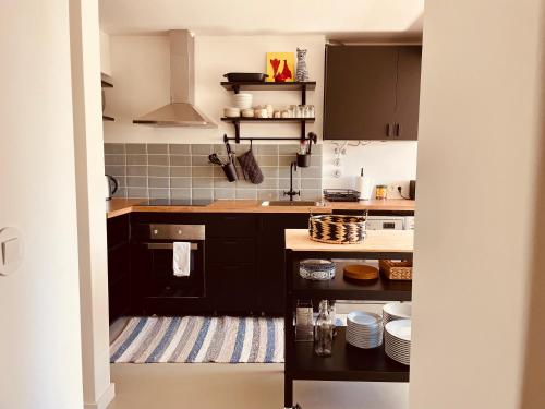a kitchen with black cabinets and white appliances at Live it up Marvila in Lisbon