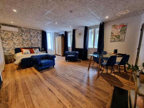 a bedroom with a bed and a table and chairs at LE MANOIR- CLUNY in Cluny