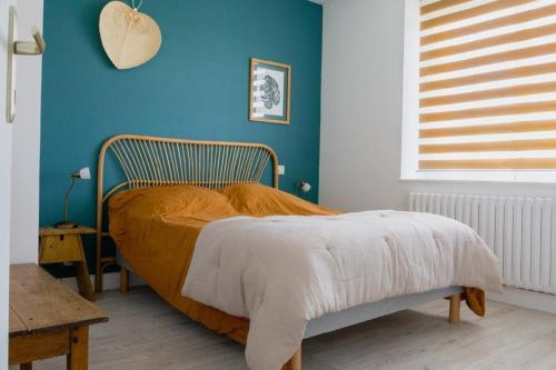 a bedroom with a bed with a blue wall at Kerfloreve in Plouescat