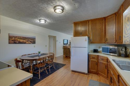 a kitchen with a white refrigerator and a table at Badlands Suite Less Than 1 Mi to Teddy Roosevelt Park! in Medora