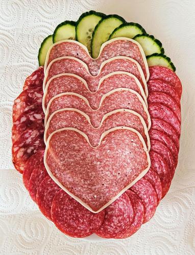 a heart shaped cake with meat and cucumbers on a plate at Hotel Wappenhof in Braunlage