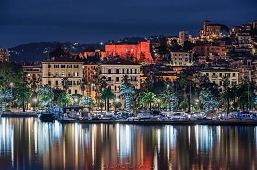 a city lit up at night with boats in the water at Profumi di mare Resort in La Spezia