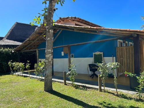 a blue and white house with a tree in the yard at Céu Azul Pousada in Arraial d'Ajuda