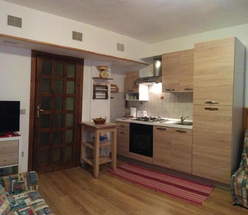 a kitchen with wooden cabinets and a stove top oven at Mountain View Apartment with Garden, Roccaraso in Roccaraso