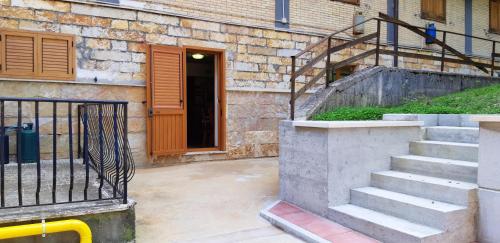 a set of stairs leading to a building with a door at Mountain View Apartment with Garden, Roccaraso in Roccaraso