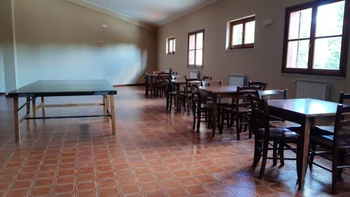 a dining room with tables and chairs and windows at Mountain View Apartment with Garden, Roccaraso in Roccaraso