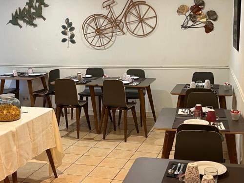 a restaurant with tables and chairs and a bike on the wall at Le Clos d'Orange - Hotel & ville de Provence in Orange