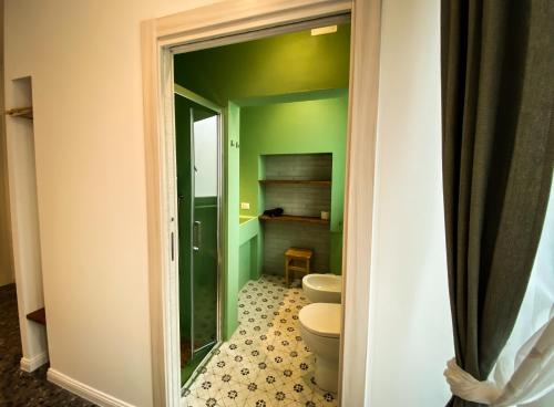 baño con aseo y pared verde en Taffetà b&b, en Crispiano