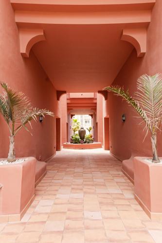 a hallway with two palm trees in a building at Nordik Apartments Village - Torrox "Tønsberg" in Torrox Costa