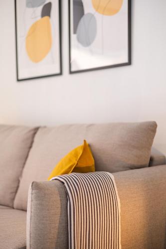 a couch with a yellow blanket on top of it at Nordik Apartments Village - Torrox "Tønsberg" in Torrox Costa