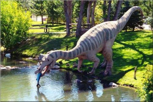 a statue of a dinosaur standing in the water at Tskaltubo Plaza Hotel in Tskaltubo