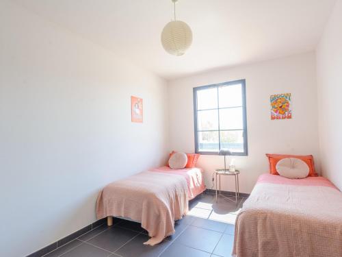 2 łóżka w pokoju z białymi ścianami i oknem w obiekcie Maison Angoulins: 6 Pers, Mer à 150m, WIFI, Terrasse, Équipée Bébé - FR-1-535-45 w mieście Angoulins