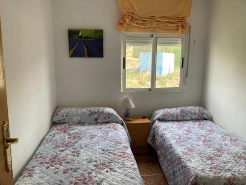 - une chambre avec 2 lits et une fenêtre dans l'établissement La Casa de Paco el Ventero Los Bolillos, à Almócita