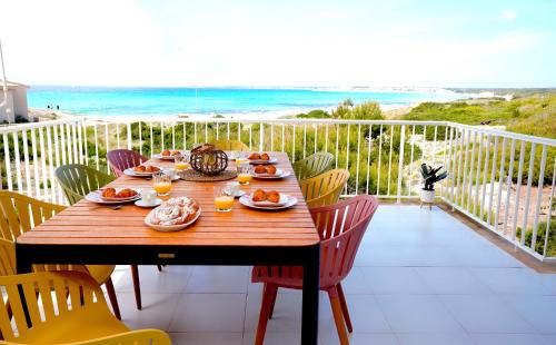 - une table en bois sur un balcon avec vue sur l'océan dans l'établissement Apartments Es Trenc, à Ses Covetes