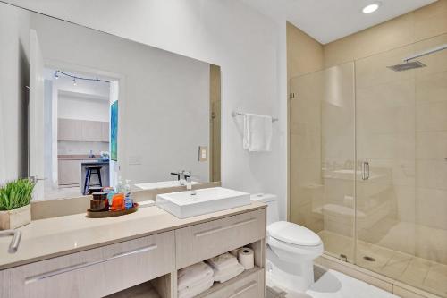 een badkamer met een wastafel, een toilet en een douche bij Oceanfront Condo Direct Ocean & Beach Club Access in Hollywood
