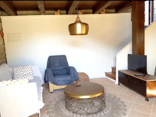 sala de estar con sofá, mesa y TV en 2 bedrooms house with furnished garden at Las Colladas, en Las Colladas