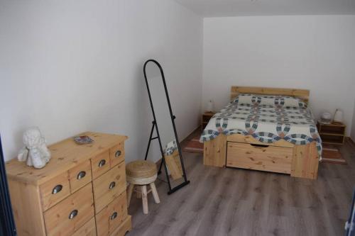 une chambre avec un lit et une commode en bois dans l'établissement APPARTEMENT NEUF ET INDÉPENDANT DANS REZ-DE-VILLA, à Vallauris