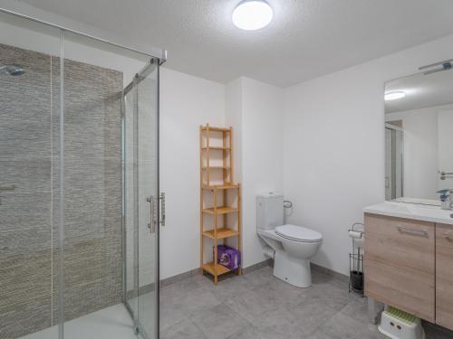 La salle de bains est pourvue de toilettes et d'une cabine de douche en verre. dans l'établissement Appartement Neuf 3* à Mimizan - 100m de l'Océan, Piscine, Clim, WiFi, 4 Pers, Ménage inclus - FR-1-50-112, à Mimizan