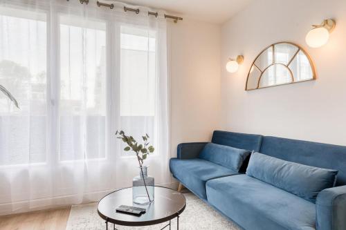 uma sala de estar com um sofá azul e uma mesa em The Blue and Gold Cocoon Appart hotel em Viry-Châtillon