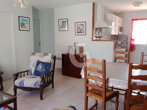 une cuisine avec une table et des chaises dans une pièce dans l'établissement Maison de vacances à La Tranche-sur-Mer, 800m plage, commerces à pied, terrasse, parking, 4 pers - FR-1-357-302, à La Tranche-sur-Mer