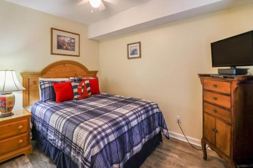 a bedroom with a bed and a flat screen tv at Tybee Summer Winds 523 Condo in Tybee Island