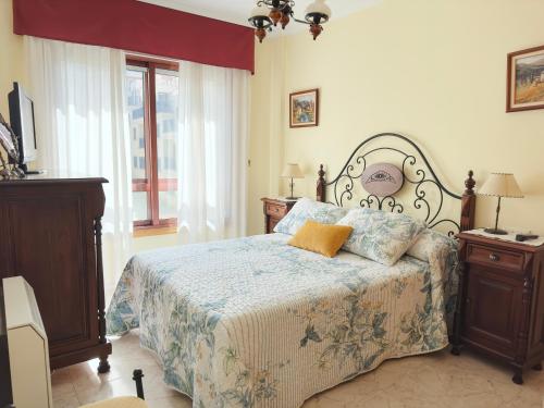 a bedroom with a bed and two night stands and a window at Apartamento Florida EME in Sanxenxo