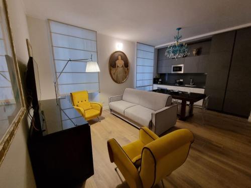 - un salon avec un canapé et des fauteuils jaunes dans l'établissement A casa di Marisa, à Rome