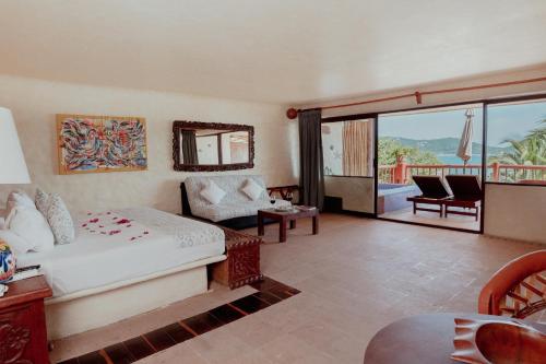a hotel room with a bed and a balcony at Hotel Aura del Mar in Zihuatanejo