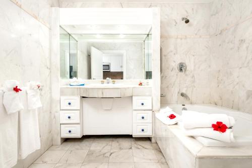 a white bathroom with a tub and a sink at Elegant Studio in Lowlands - 55 sqm - Pool in Lowlands