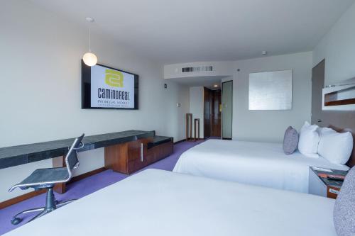 a hotel room with two beds and a desk at Camino Real Pedregal Mexico in Mexico City