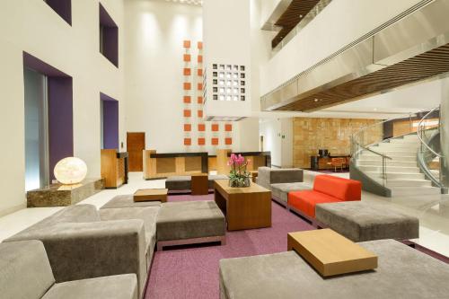 a lobby with couches and tables in a building at Camino Real Pedregal Mexico in Mexico City