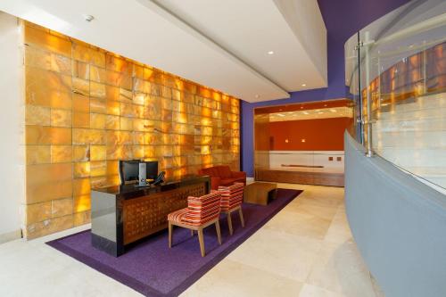 a room with a desk and two chairs and a television at Camino Real Pedregal Mexico in Mexico City