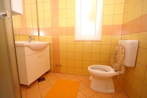 een badkamer met toilet, wastafel en raam bij Cosy Apartment in Žrnovo - 30 sqm with Shared Pool in Korčula