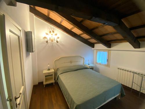 Schlafzimmer mit einem Bett und einem Kronleuchter in der Unterkunft Casa Rossa - charmantes Ferienhaus in der Altstadt von Chioggia in Chioggia