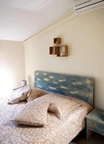 a bedroom with a bed with a painting on the wall at Harmony Villa in Kalymnos