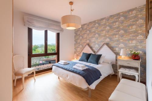 a bedroom with a bed and a desk and a window at Bluebol, apartamento a 2 km de Llanes in Llanes