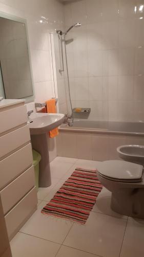 een badkamer met een wastafel, een toilet en een bad bij Amorosa Beach Sun And Sea in Viana do Castelo