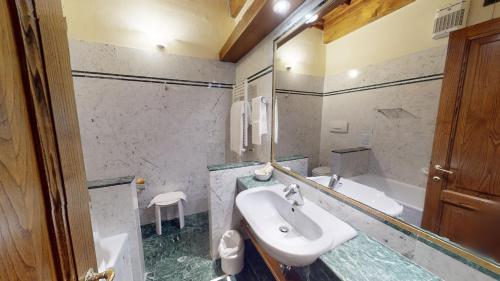 a bathroom with a sink and a bath tub at Hotel Palazzo Squarcialupi in Castellina in Chianti