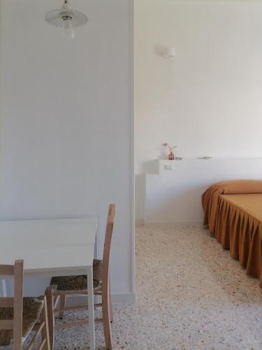 a white room with a table and a bed at Casa Quieta in Marina di Camerota