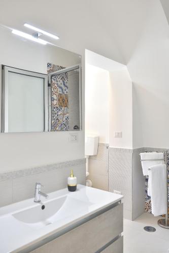 a white bathroom with a sink and a mirror at Bright Apartment in Minori, 67 sq.m, Near Beaches in Minori