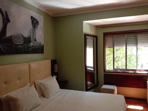 - une chambre avec un lit blanc et une fenêtre dans l'établissement Faria Guimaraes-Porto Centro 1, à Porto