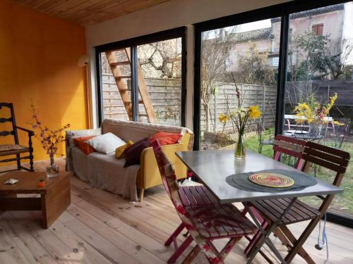 un soggiorno con tavolo e divano di Chalet d'une chambre avec jardin clos et wifi a Lamastre a Lamastre