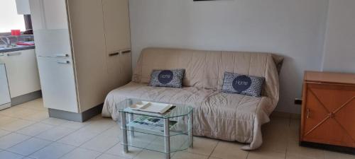 un petit salon avec un canapé et une table dans l'établissement Appartement la méridienne Le Lavandou 2 à 4 personnes, au Lavandou