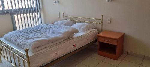 Ce lit se trouve dans un dortoir doté d'une table de chevet et d'une sidx. dans l'établissement Appartement la méridienne Le Lavandou 2 à 4 personnes, au Lavandou
